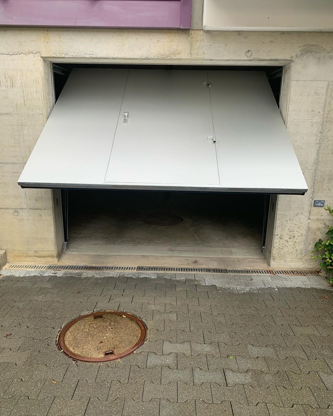 Kipptor in der Betonwand einer Tiefgarage, geöffnet