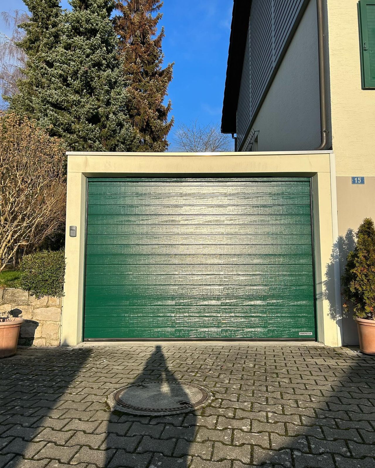 Grünes Sektionaltor an einer Garage